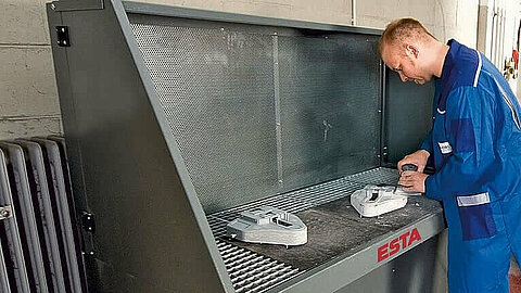 Ein Arbeiter schleift Material auf dem Absaugtisch AV, welcher sich für Prozesse wie Schweissen und Schleifen eignet